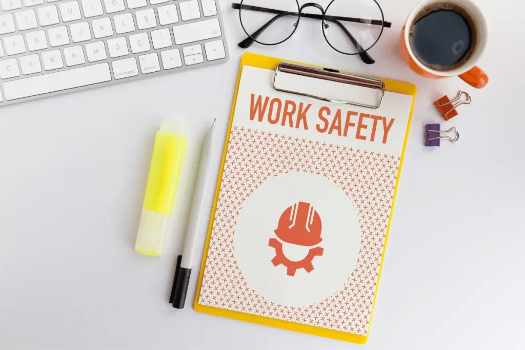 una tastiera di computer con vicino una cartella con la scritta "Work safety"