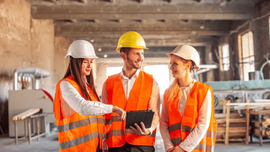RSPP ed RLS con il datore di lavoro sul cantiere, con gilet alta visibilità e casco