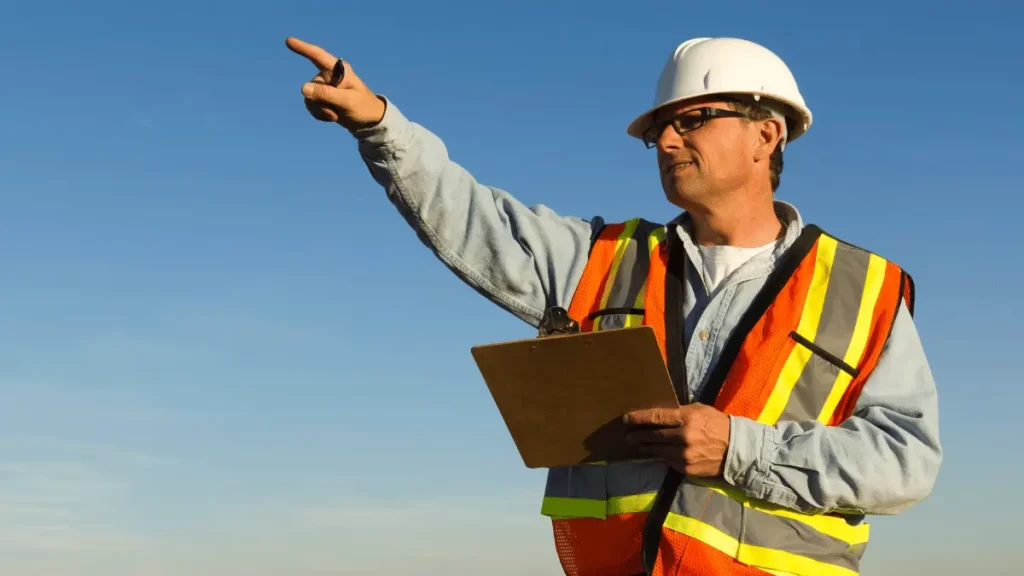Datore di lavoro con casco e giubbotto di protezione durante un sopralluogo